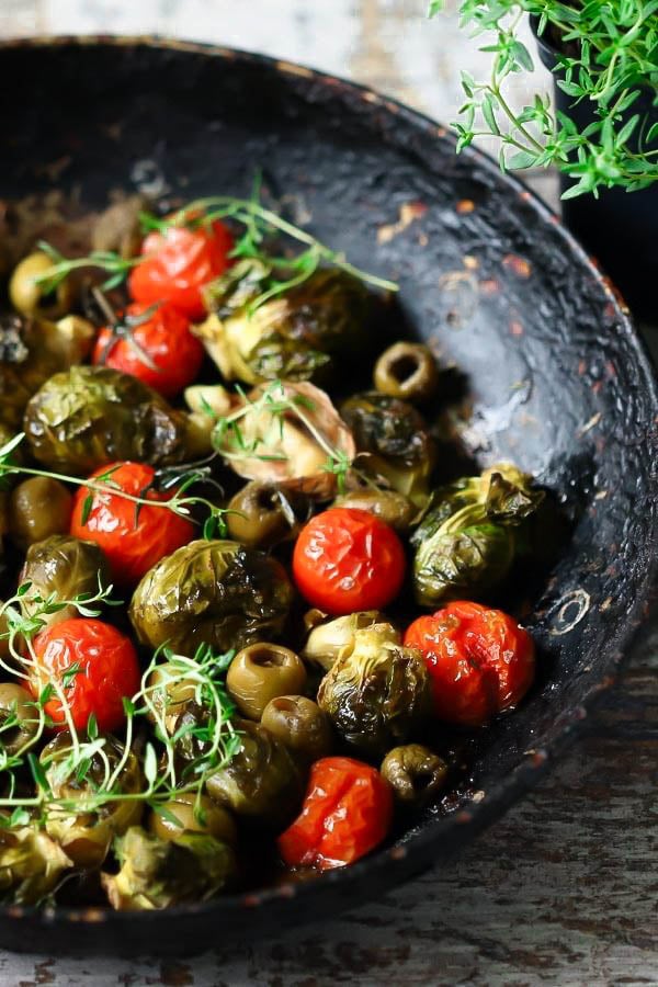 caramelized balsamic roasted brussel sprouts tomatoes and olives in a black skillet 