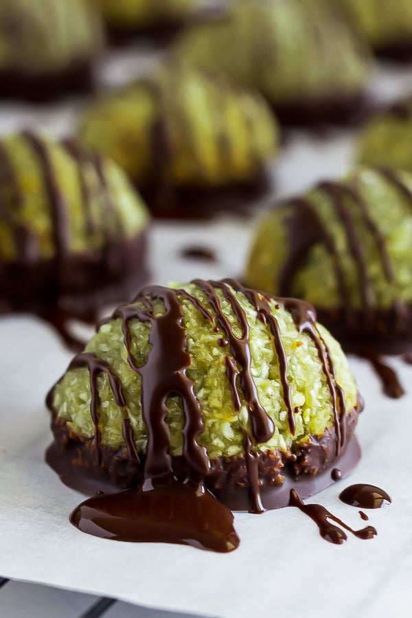 a soft chewy pistachio coconut macaroon being drizzled with melted dark chocolate 