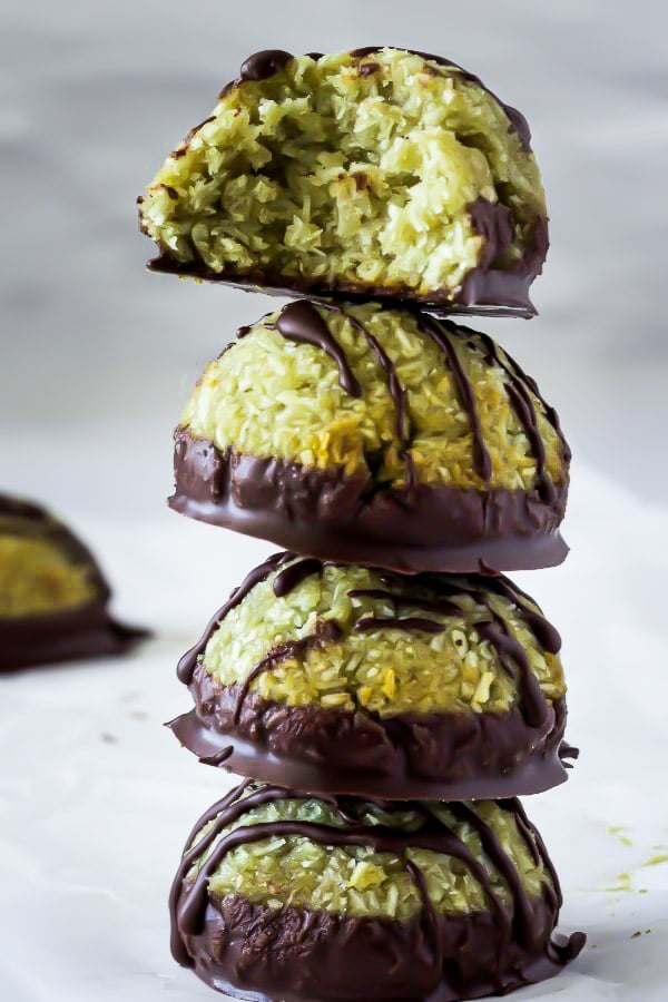 a stack of soft chewy homemade pistachio coconut macaroons dipped in chocolate