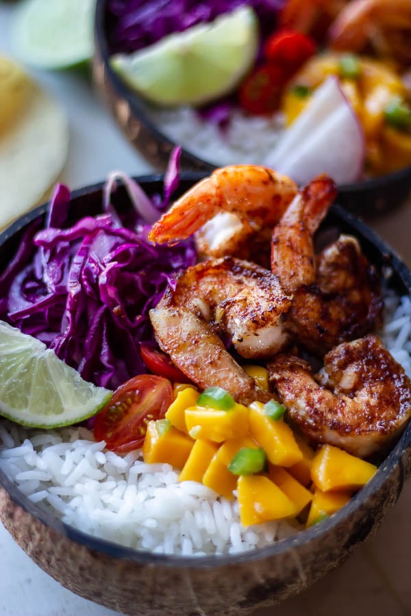 close-up of charred taco seasoned shrimp served with mango salsa and rice