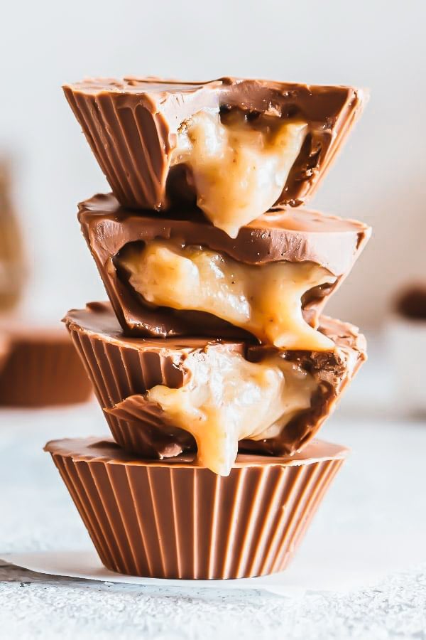 stacked vegan salted caramel chocolate cups with tahini caramel oozing out the cups