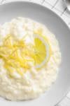lemon rice pudding on a white bowl garnished with lemon peel