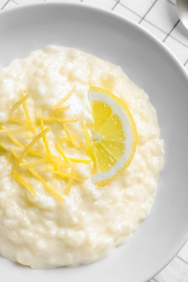 Lemon Rice Pudding served in a bowl garnished with candied lemon zest and a lemon slice