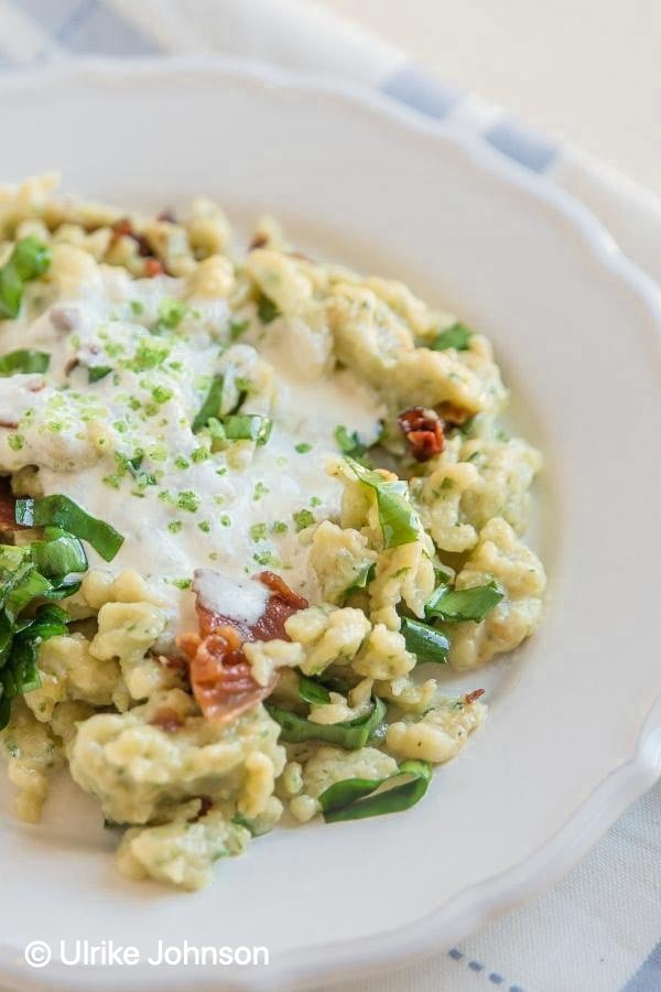 side view of a plate of German Wild Garlic Spätzle served with bacon and cheese sauce