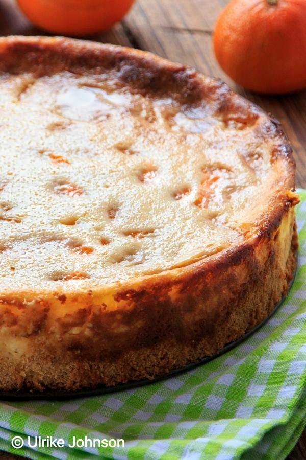 a whole German Quark Cheesecake with mandarin oranges on a rustic tables
