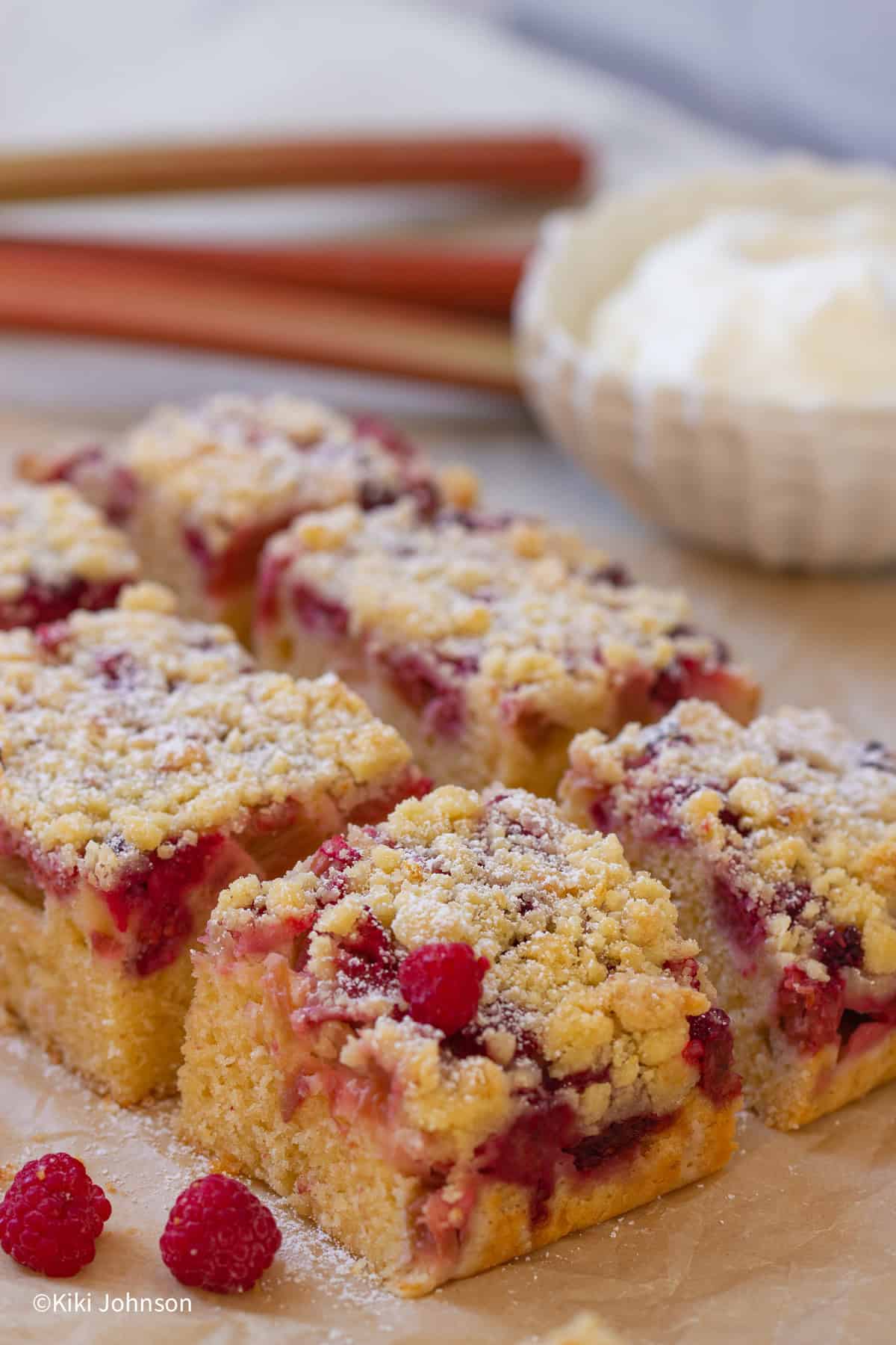 Himbeer Rhabarberkuchen vom Blech mit Streuseln auf einem Stück Backpapier