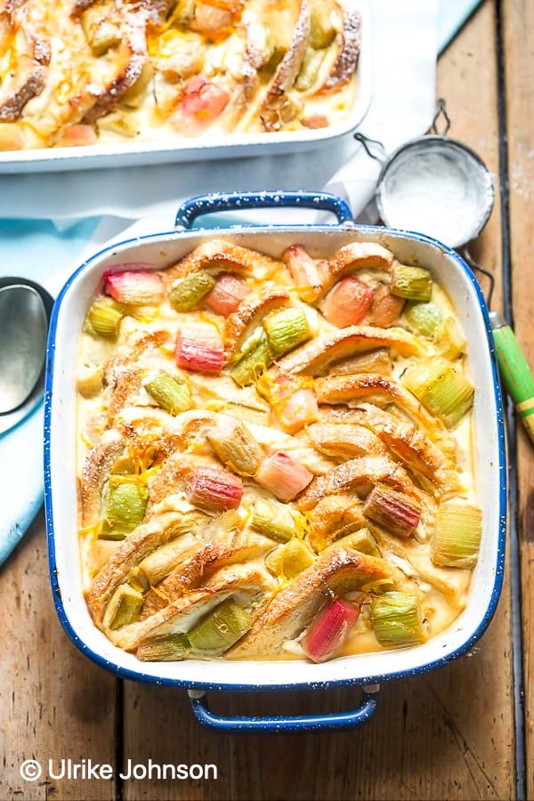 rhubarb bread pudding in a white and blue casserole dish