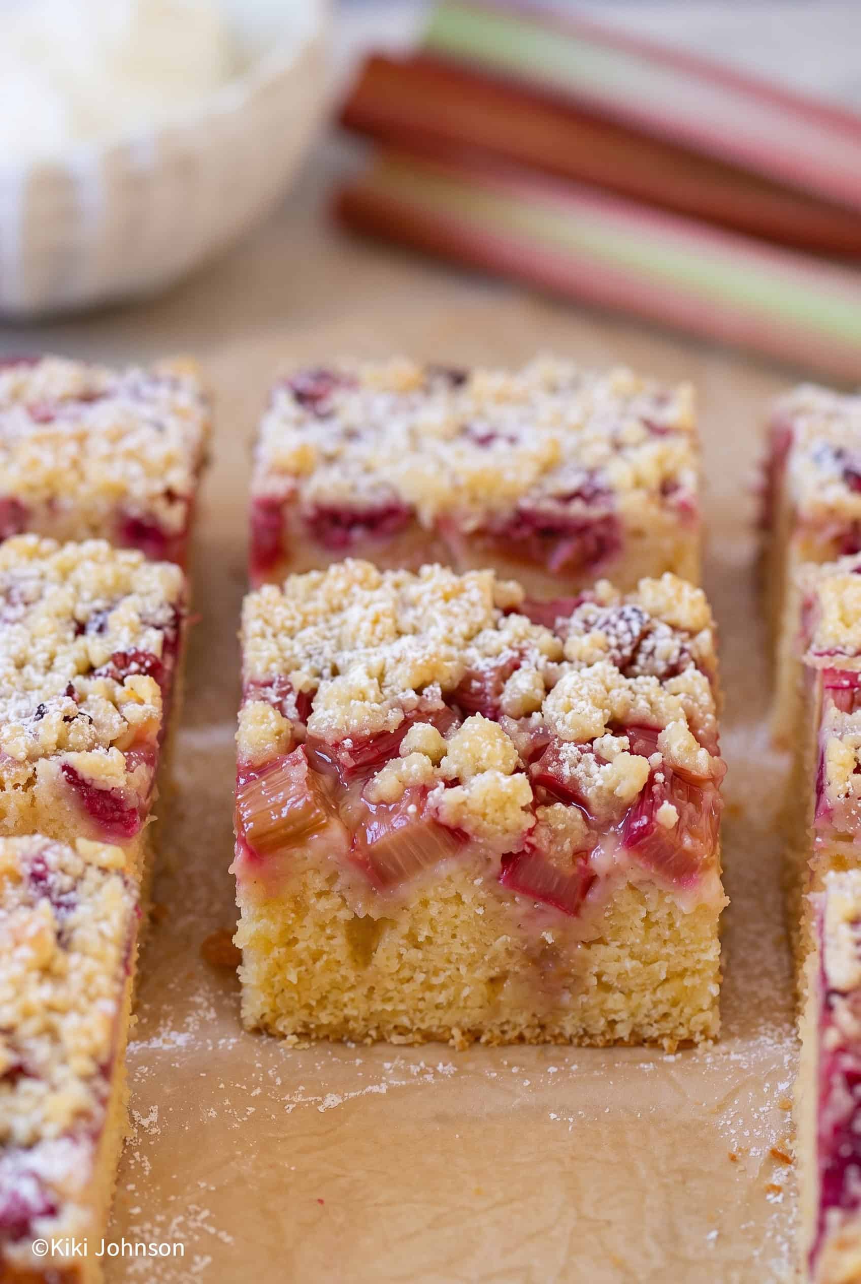 Himbeer Rhabarber Streuselkuchen vom Blech mit Puderzucker bestäubt.