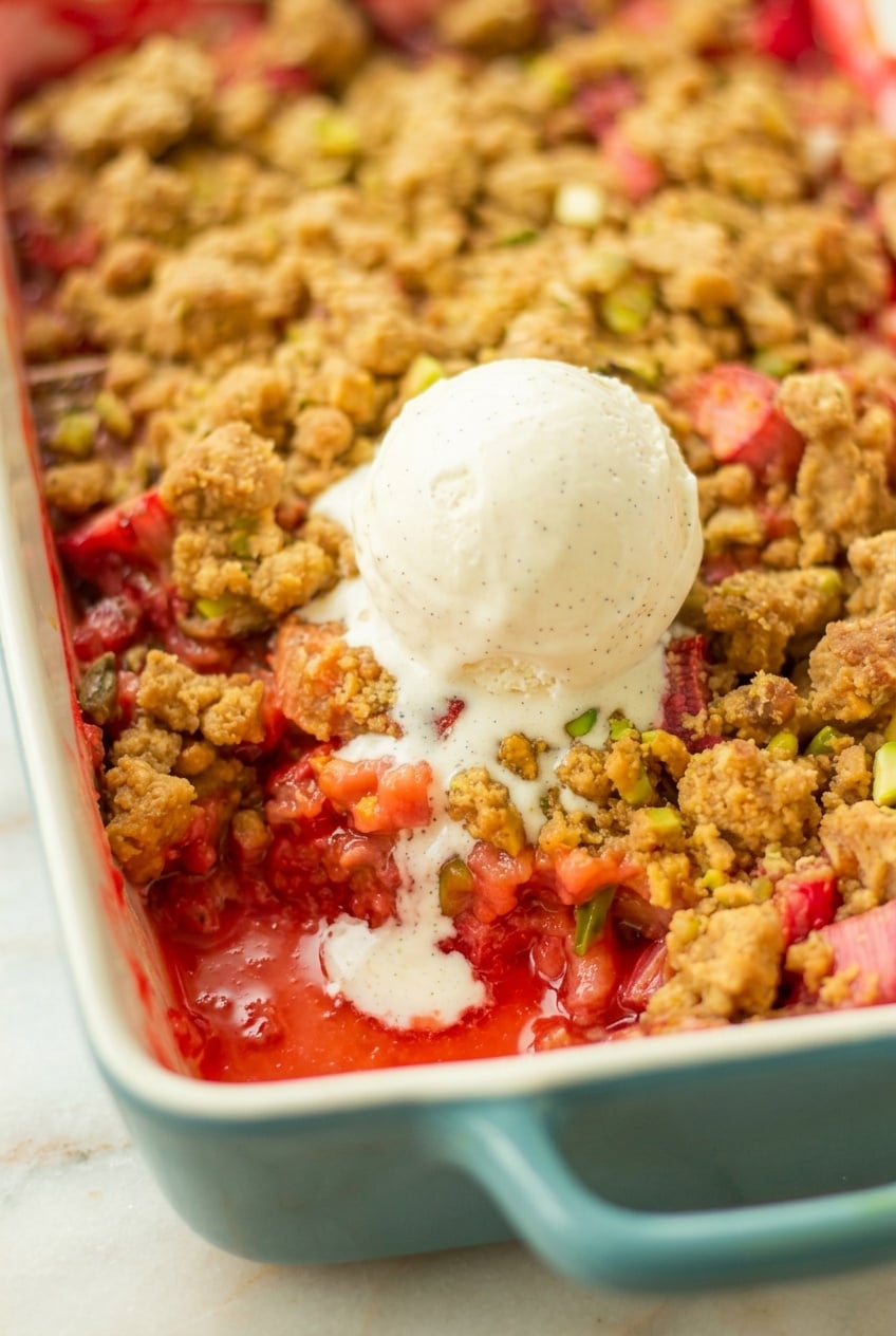 Erdbeer Rhabarber Streusel Ein Auflauf Form mit Erdbeer Rhabarber Crumble serviert mit einer Kugel Vanilleeis