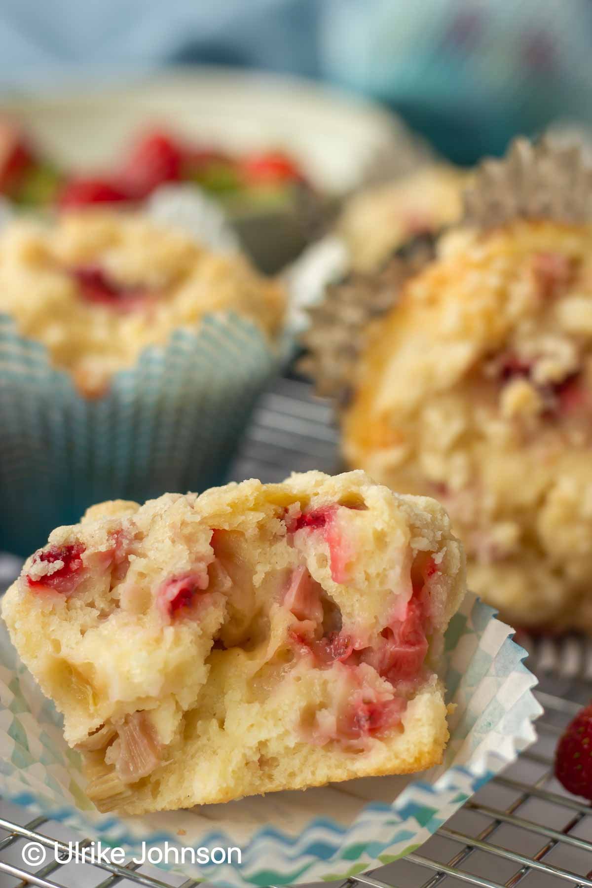 a halved homemade strawberry rhubarb muffin with sour cream and streusel topping 