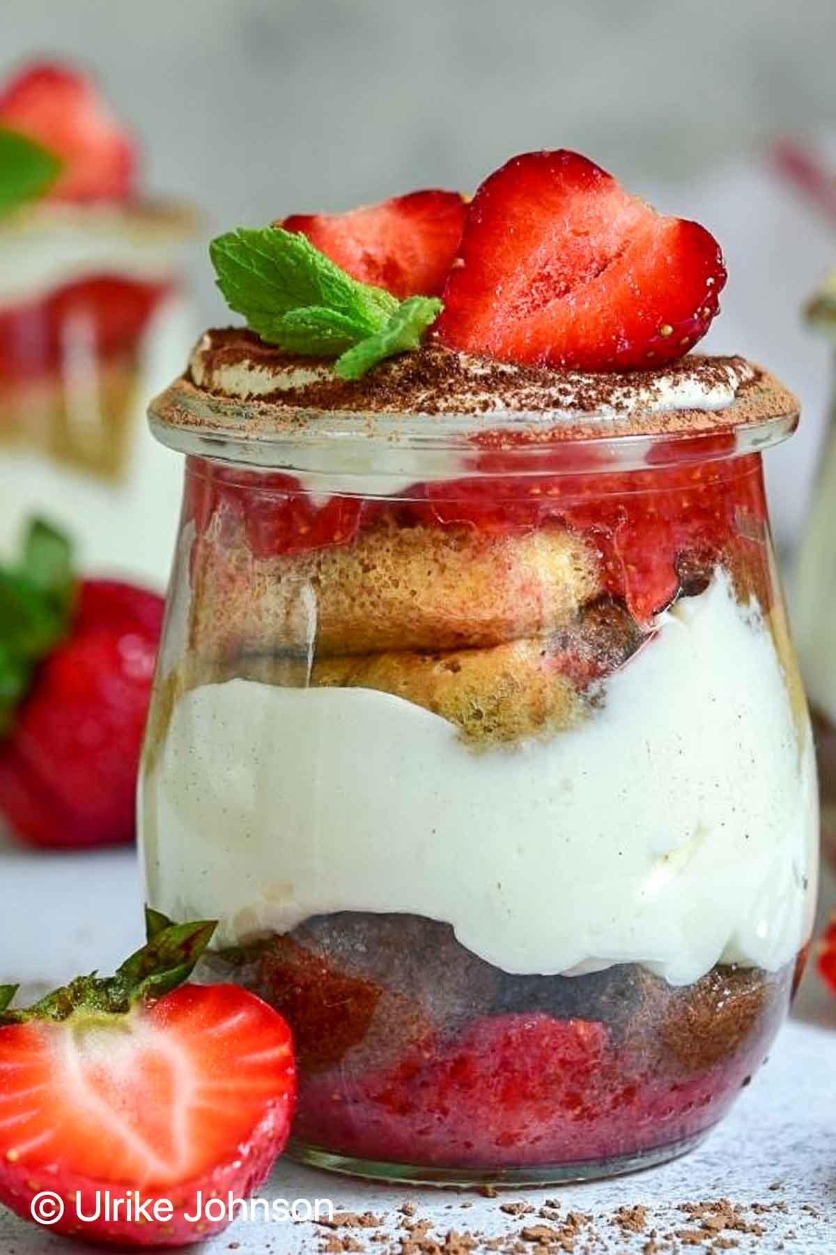 eggless strawberry tiramisu in a glass layered with mascarpone cream, strawberries and coffee rum soaked ladyfingers 
