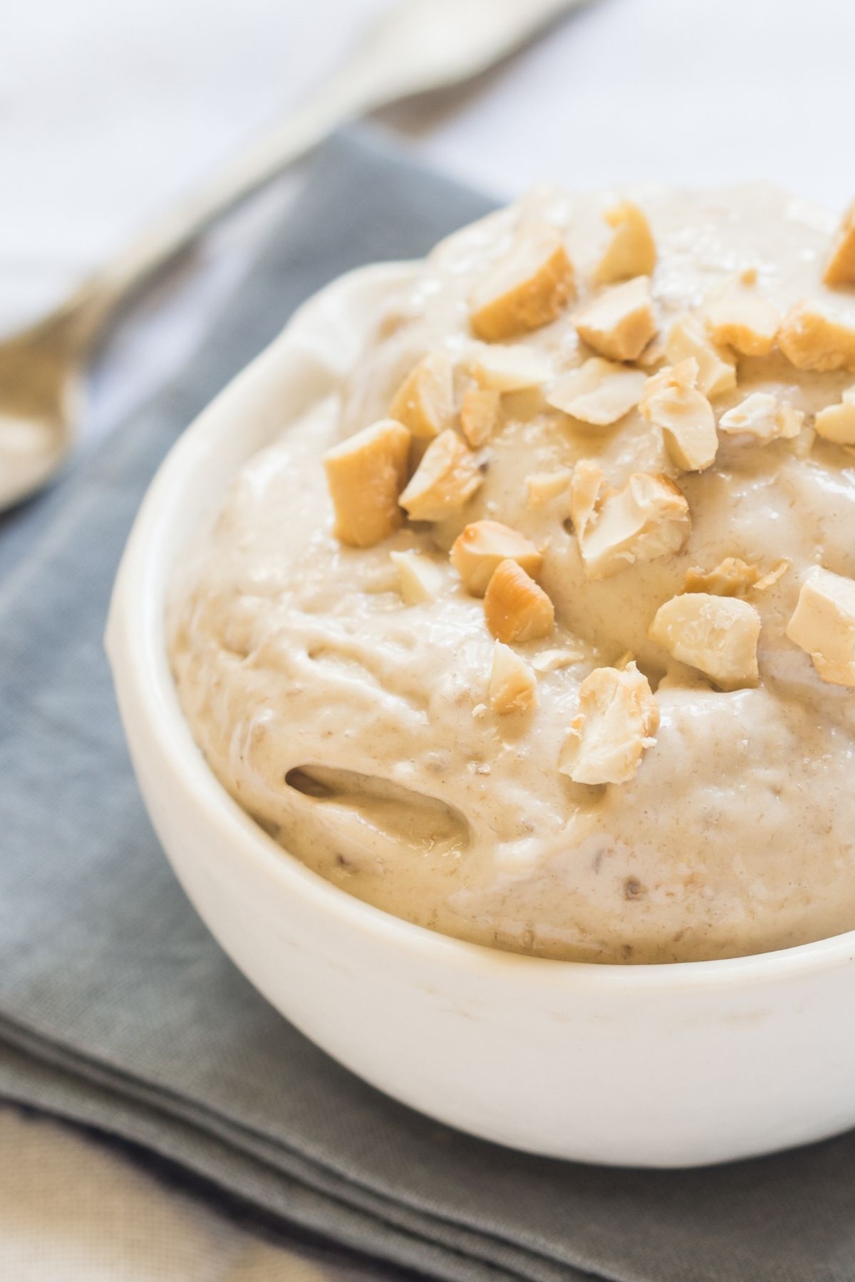 a bowl of creamy vegan banana peanut butter nice cream topped with chopped peanuts