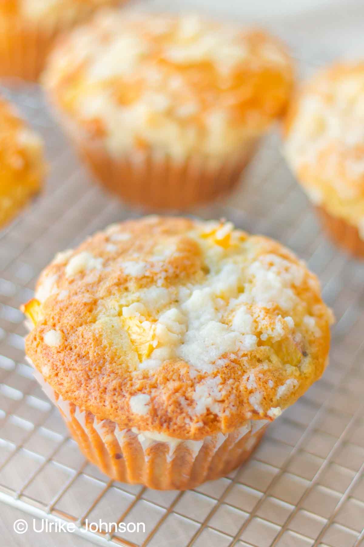 peach cobbler muffins with streusel topping cooling on a wire rack 