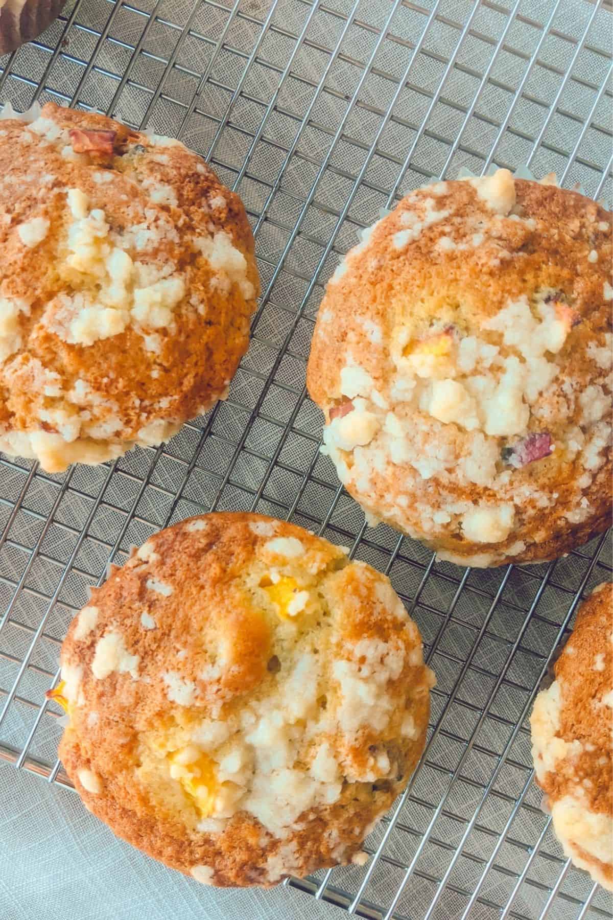 frisch gebackene Goldige Pfirsich Muffins mit Streusel kühlen auf einem Kuchengitter 