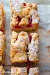 German Plum Crumble Cake with Streusel Topping sliced into squares and dusted with icing sugar