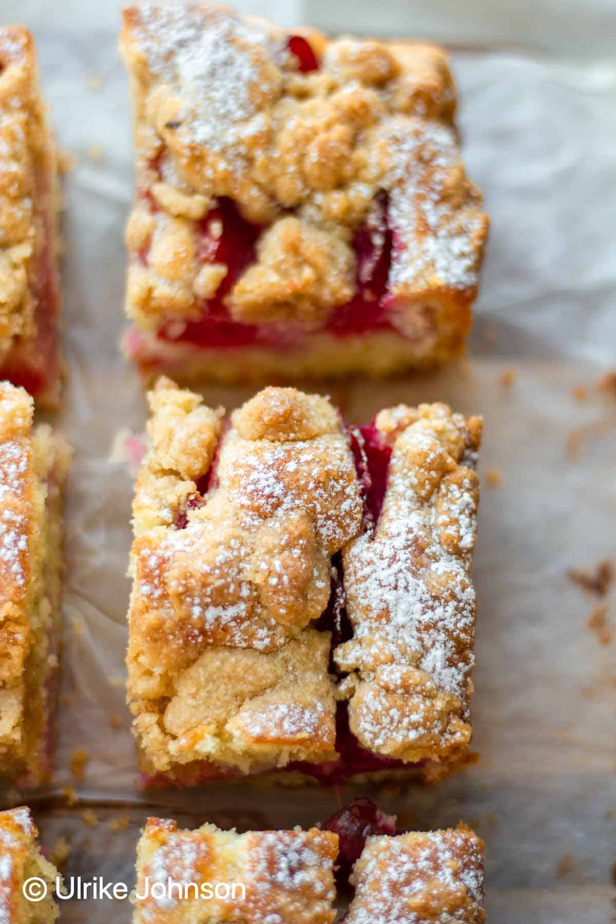 Traditional German Plum Crumble Cake with Streusel topping served sliced on a wooden board