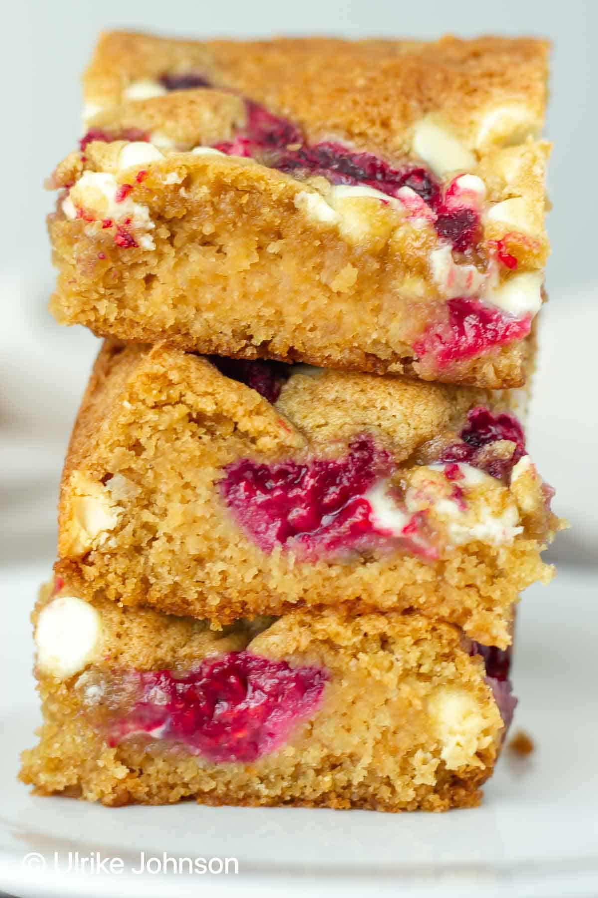 stacked glutenfree small batch white chocolate and raspberry blondies on a dessert plate