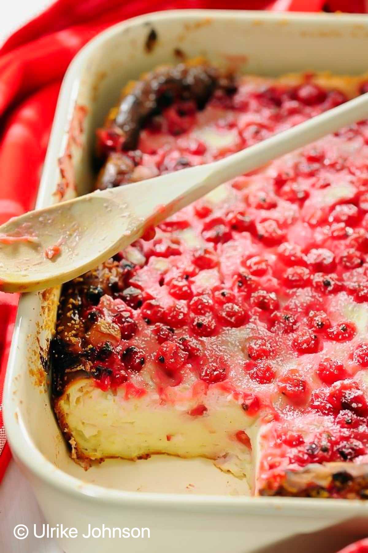 German Cheesecake Casserole with red currants in a white casserole dish