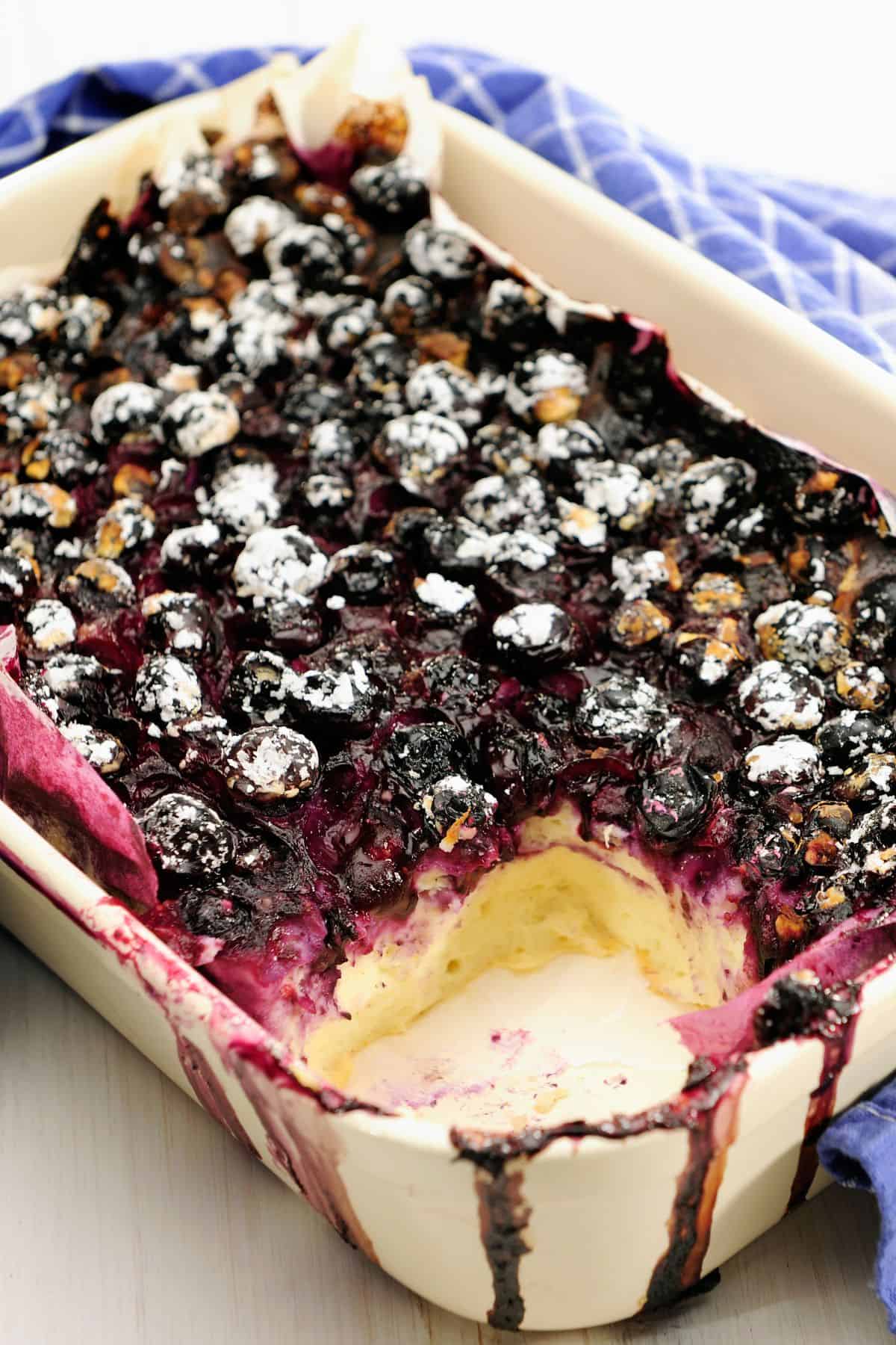 low carb German cheesecake casserole topped with blueberries in a white casserole dish.