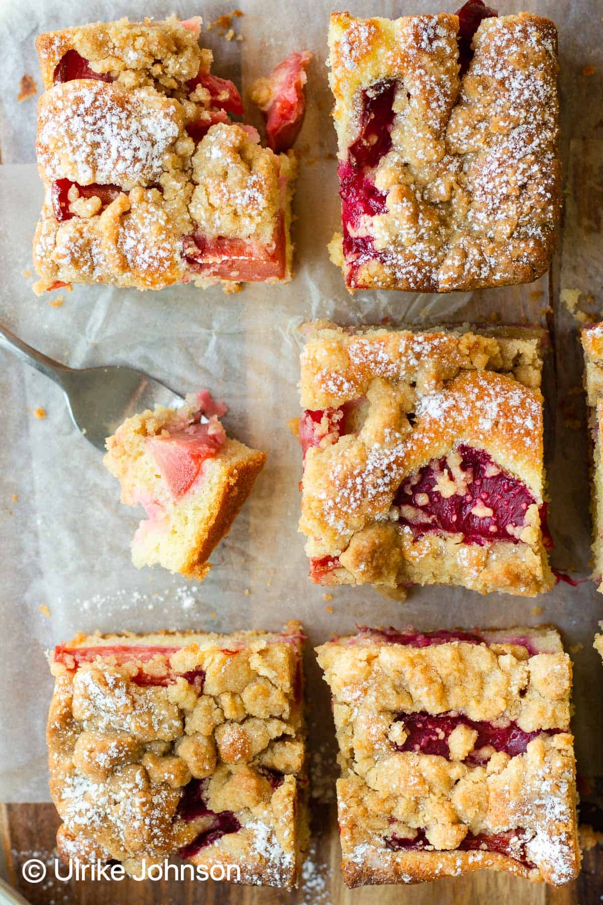 German plum crumble cake with streusel topping served on a wooden chopping board 
