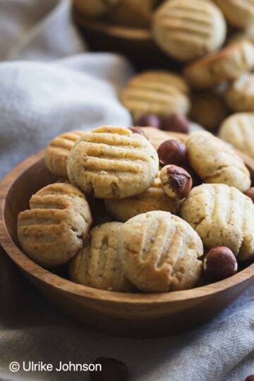 German Hazelnut Cookies and whole hazelnuts in a wooden bowl