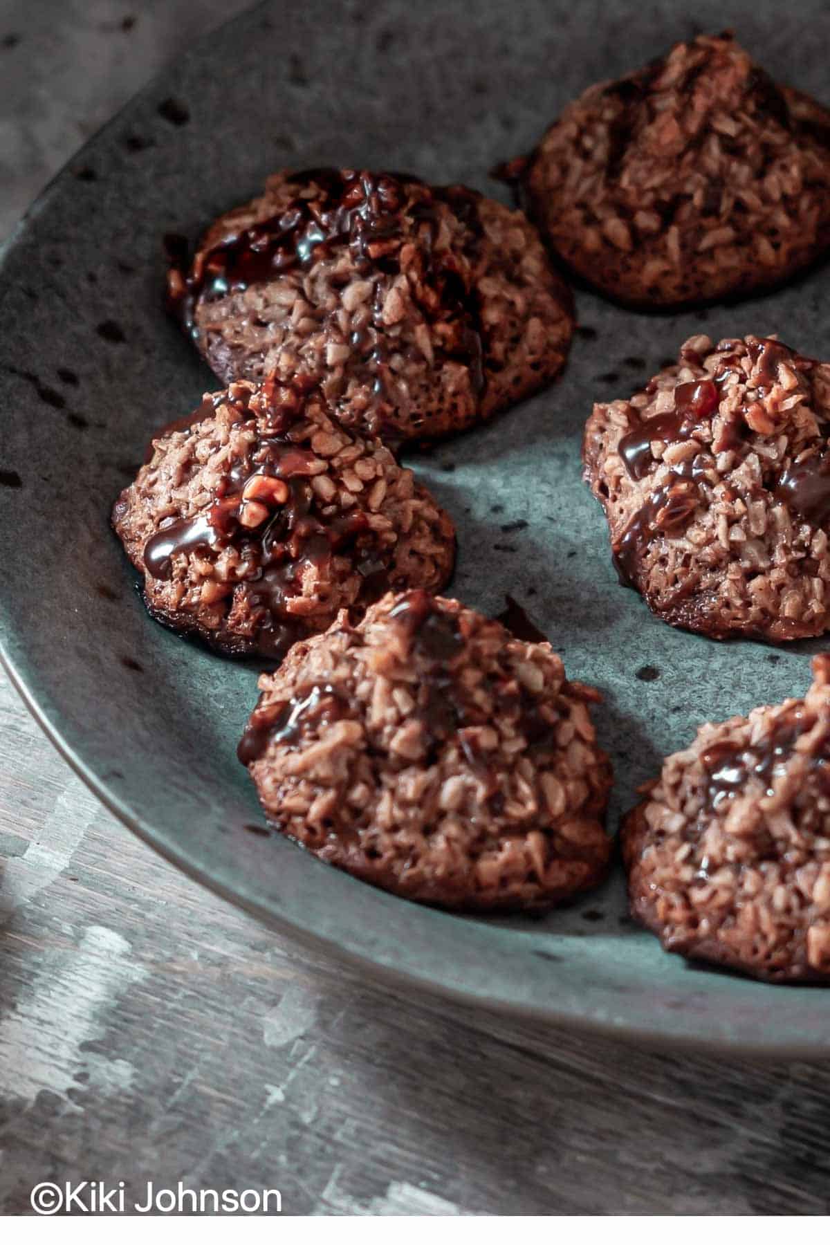 eggless dark chocolate coconut macaroons with chocolate drizzle on a blue plate