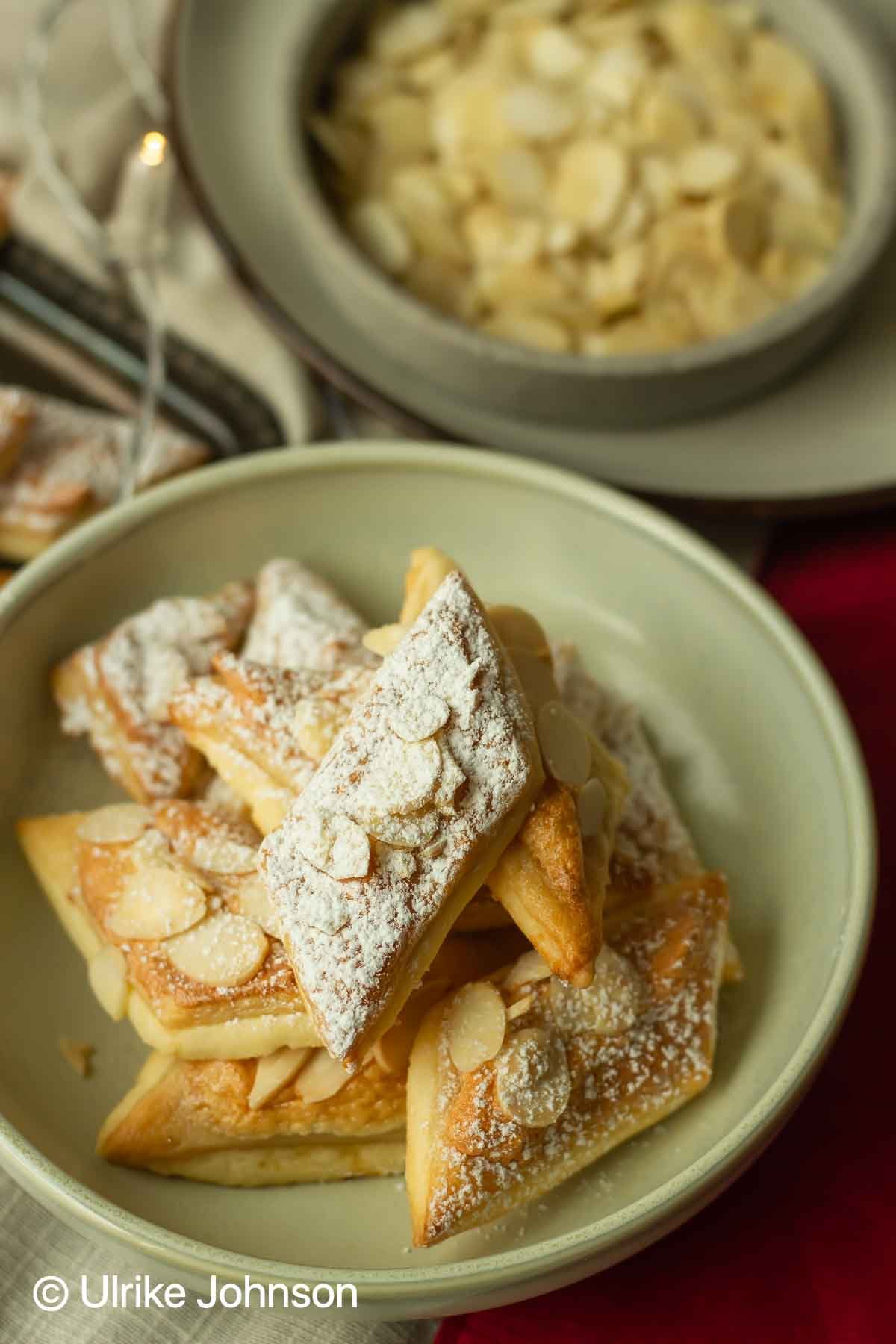 Knusprige Marzipan Plätzchen mit gehobelten Mandeln und Baiser auf einem weihnachtlichen Keksteller