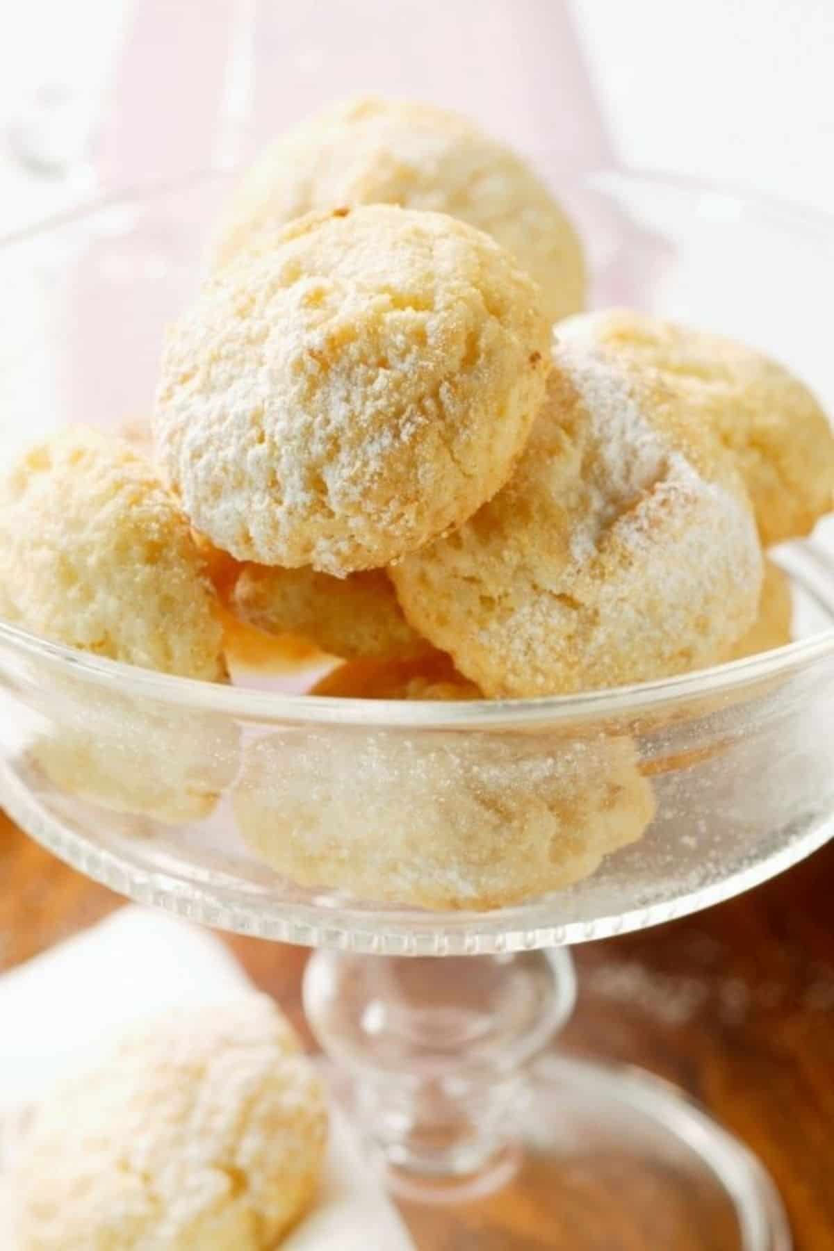 cream cheese almond cookies dusted with icing sugar in a small glass
