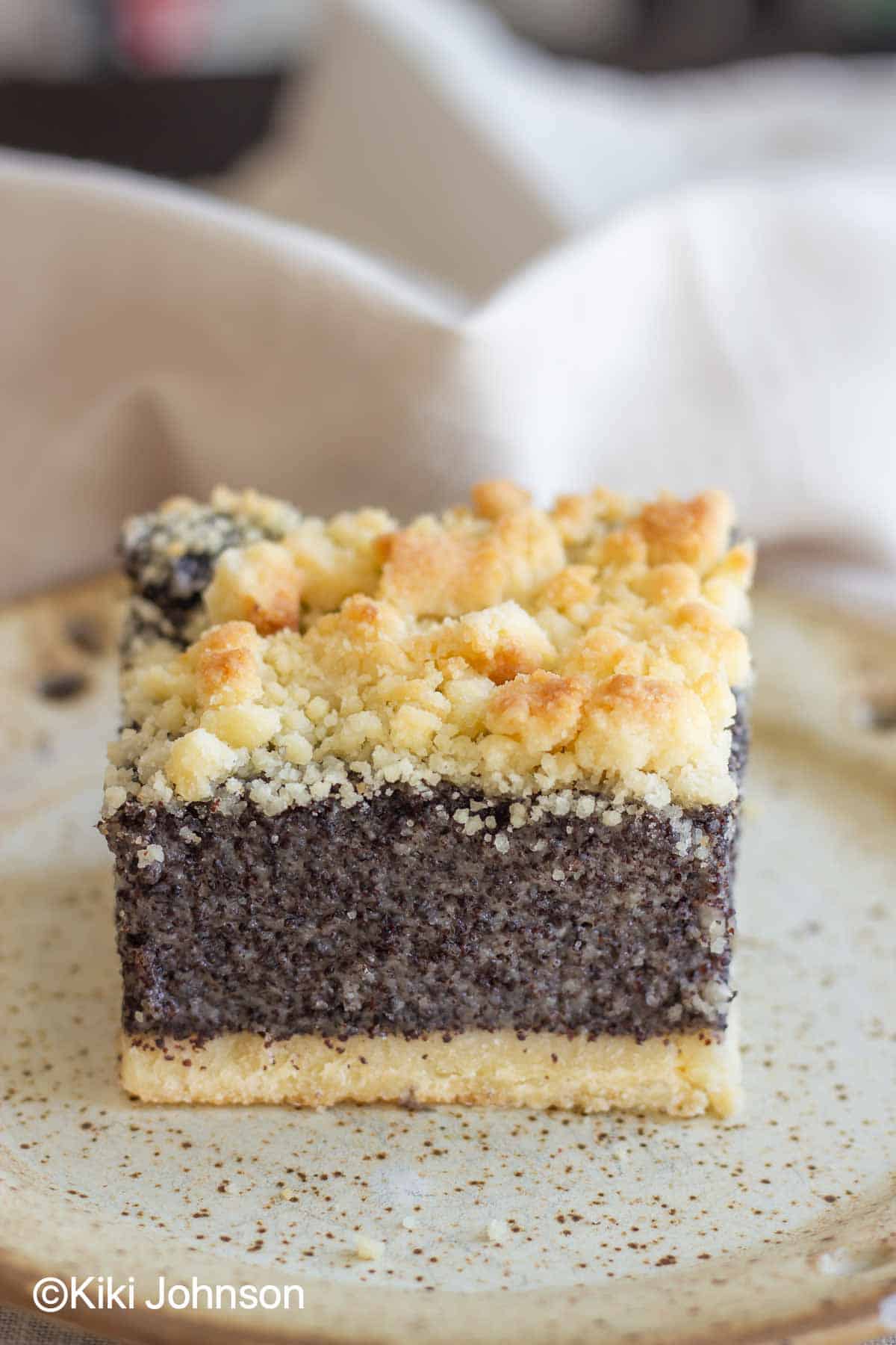 old fashioned german poppy seed cake with streusel topping on a small plate