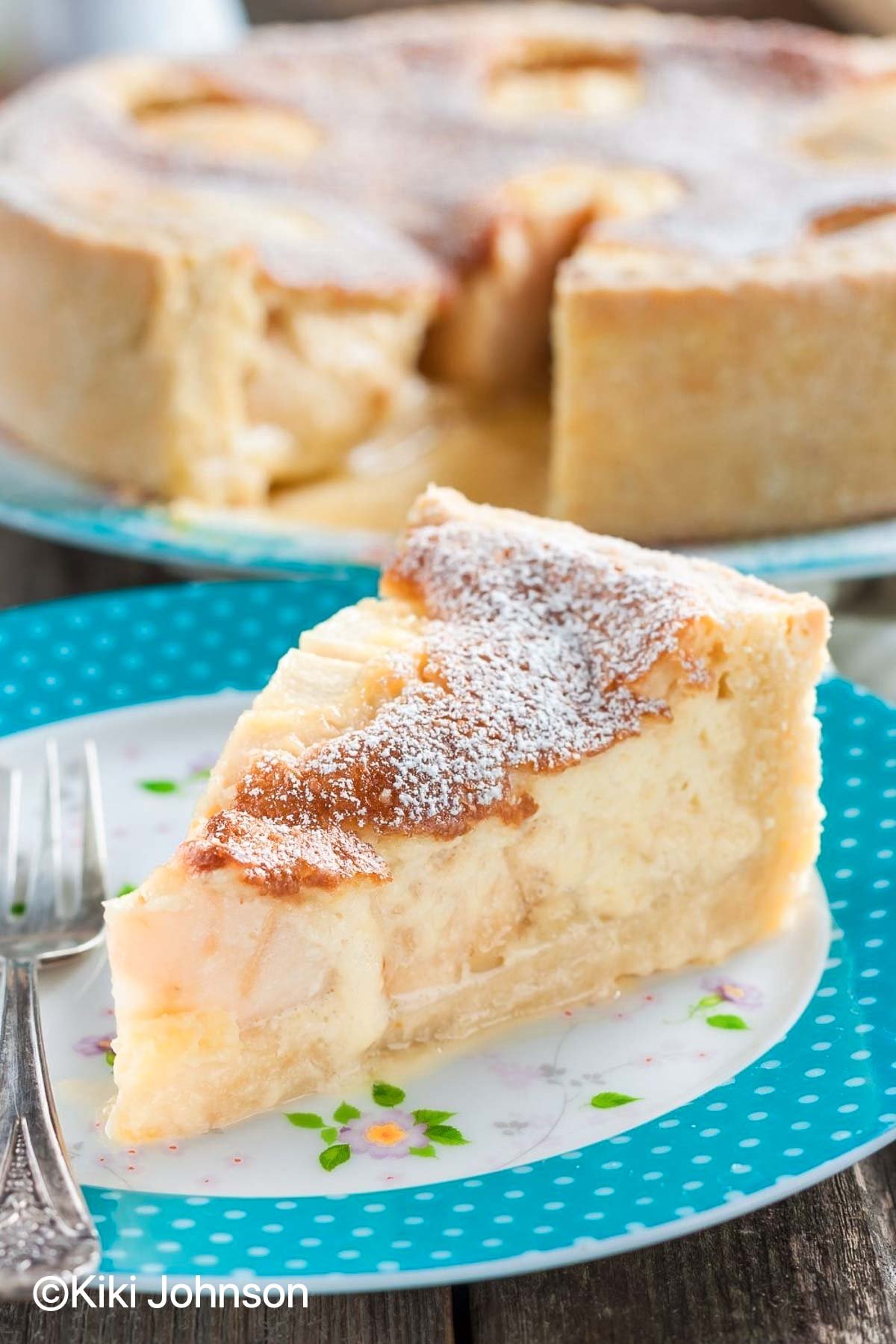 a slice of German Apple Custard Cake with creme fraiche filling on a blue cake plate