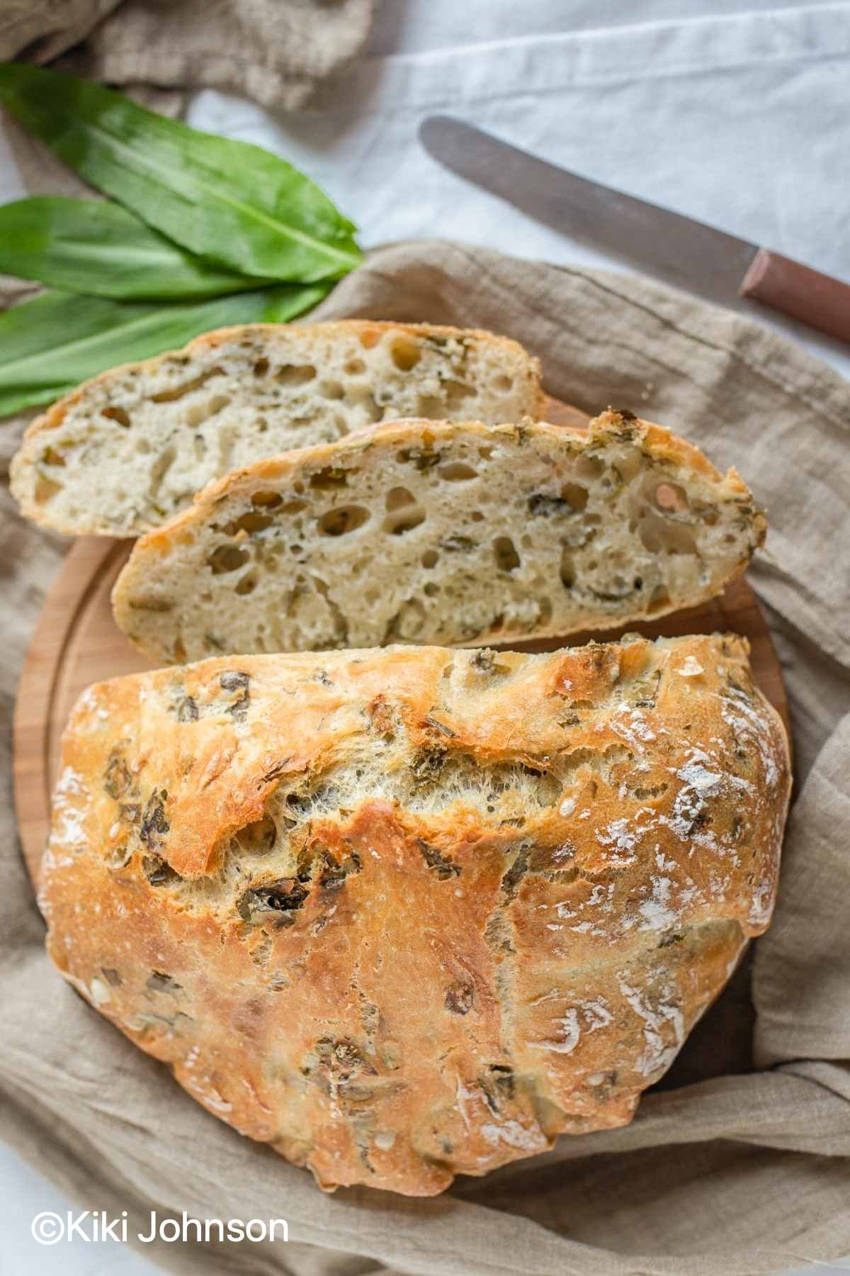 German no knead white garlic bread with wild garlic leaves on the side