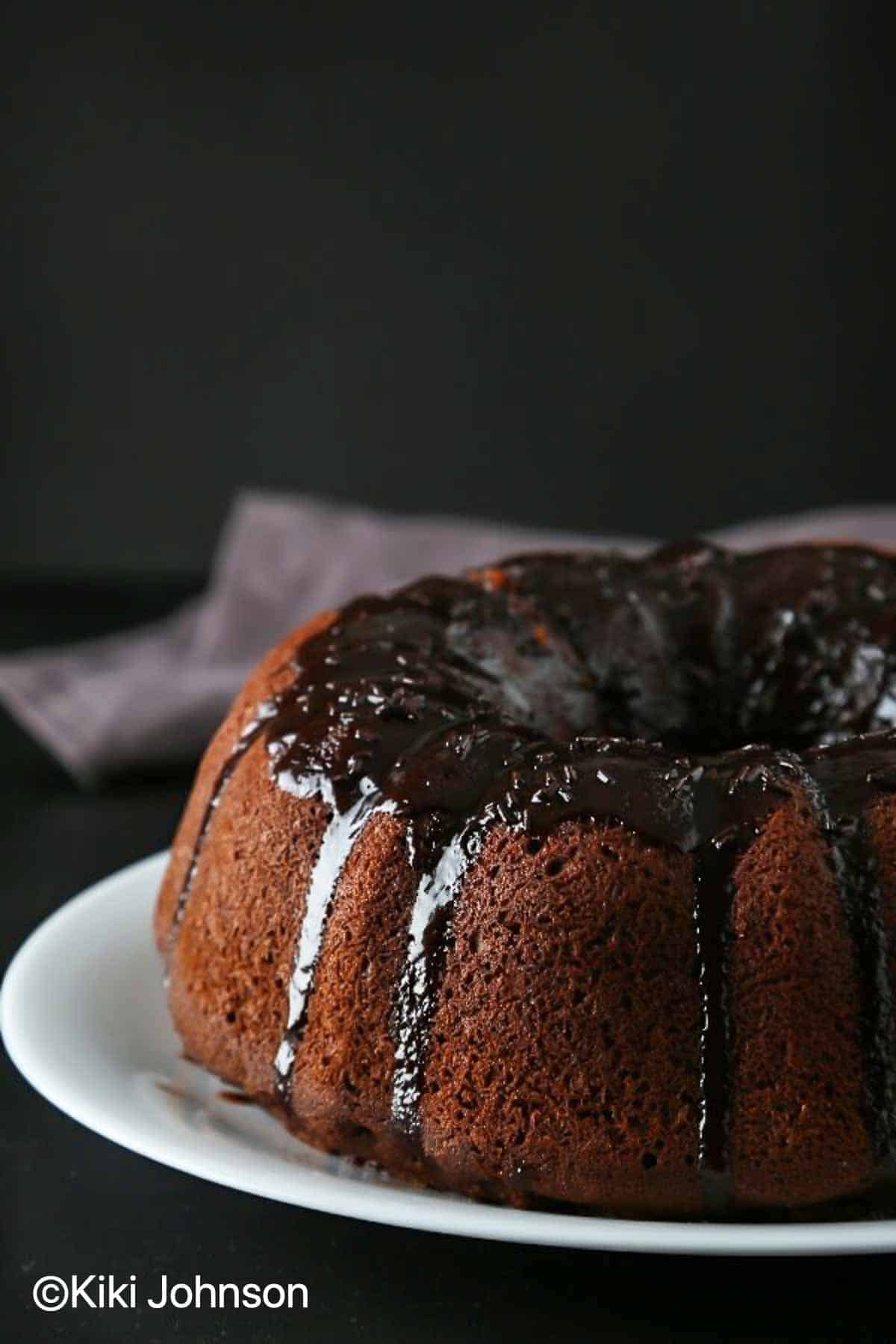 whiskey drizzle being drizzled over a warm chocolate bundt cake