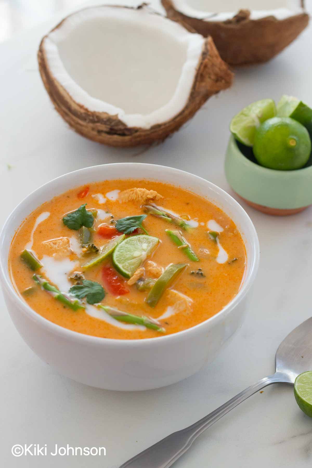 eine Schale mit roter Thai Curry Suppe mit Gemüse und Hähnchen