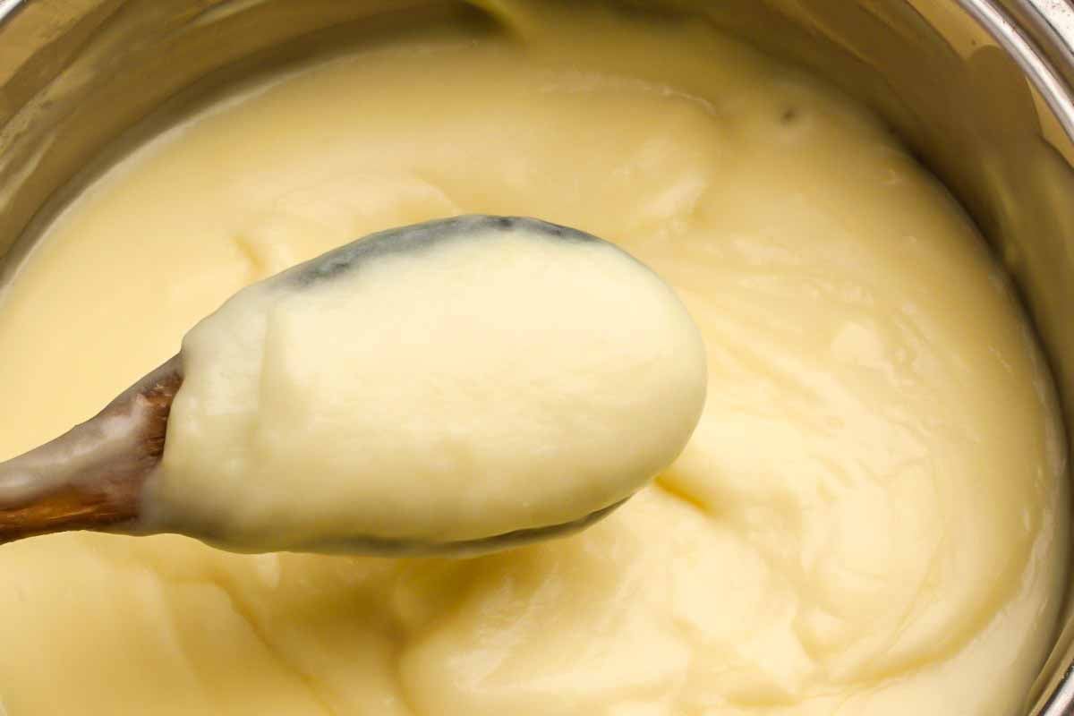 Vanillepudding wird in einem Topf gekocht für Rhabarberkuchen Rezept