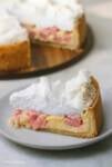 Rhabarberkuchen mit Baiser und Pudding auf einem Tortenteller