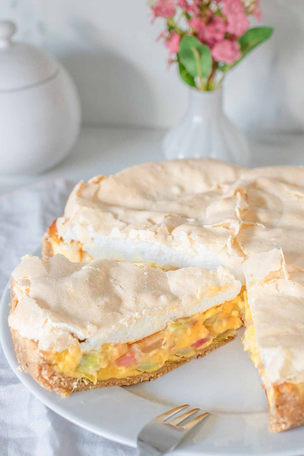 german Rhubarb Sour Cream custard pie with meringue topping on a cake platter