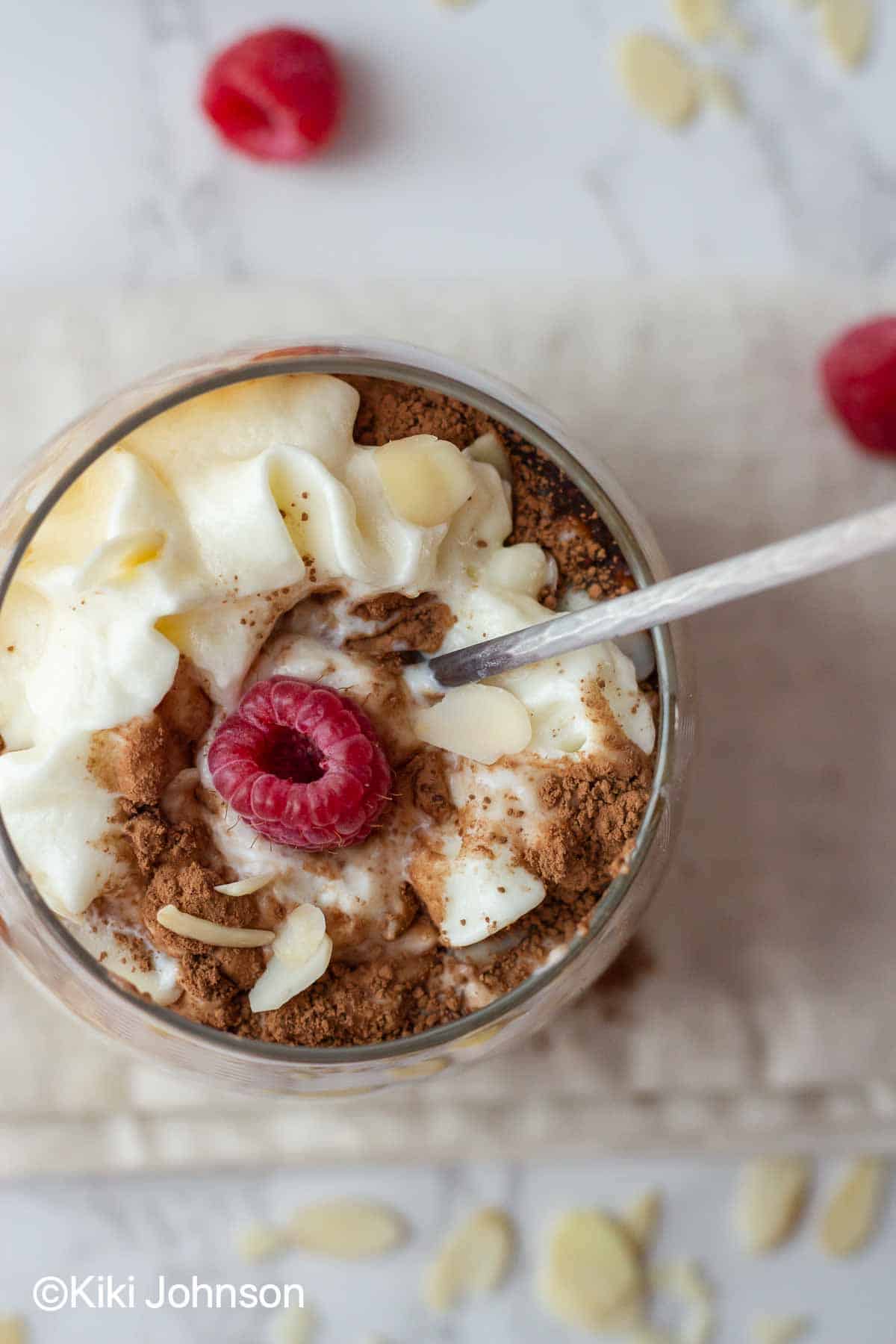 Ein Löffel wird in ein Glas mit Overnight Oats eingetaucht