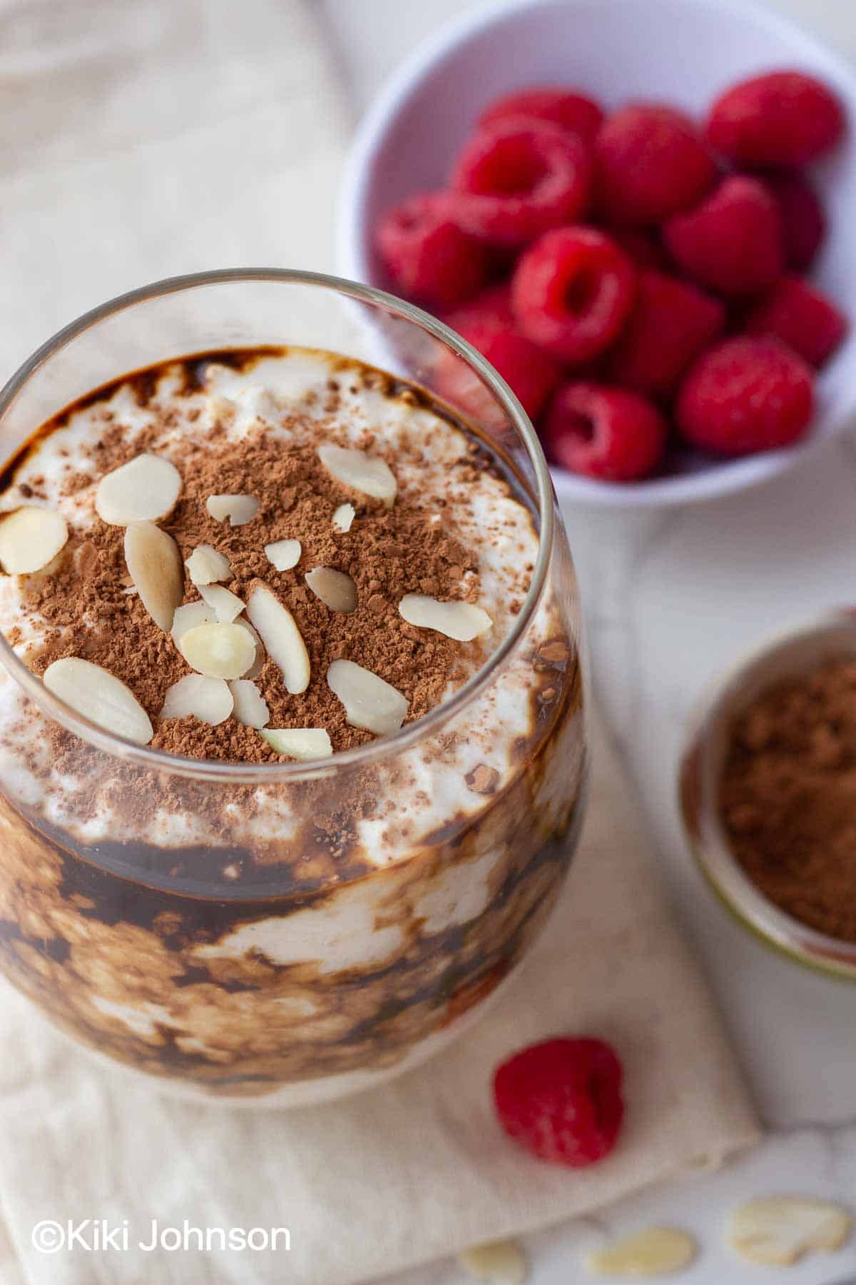 a serving of vegan coffee flavored tiramisu overnight oats dusted with cocoa powder and slivered almonds