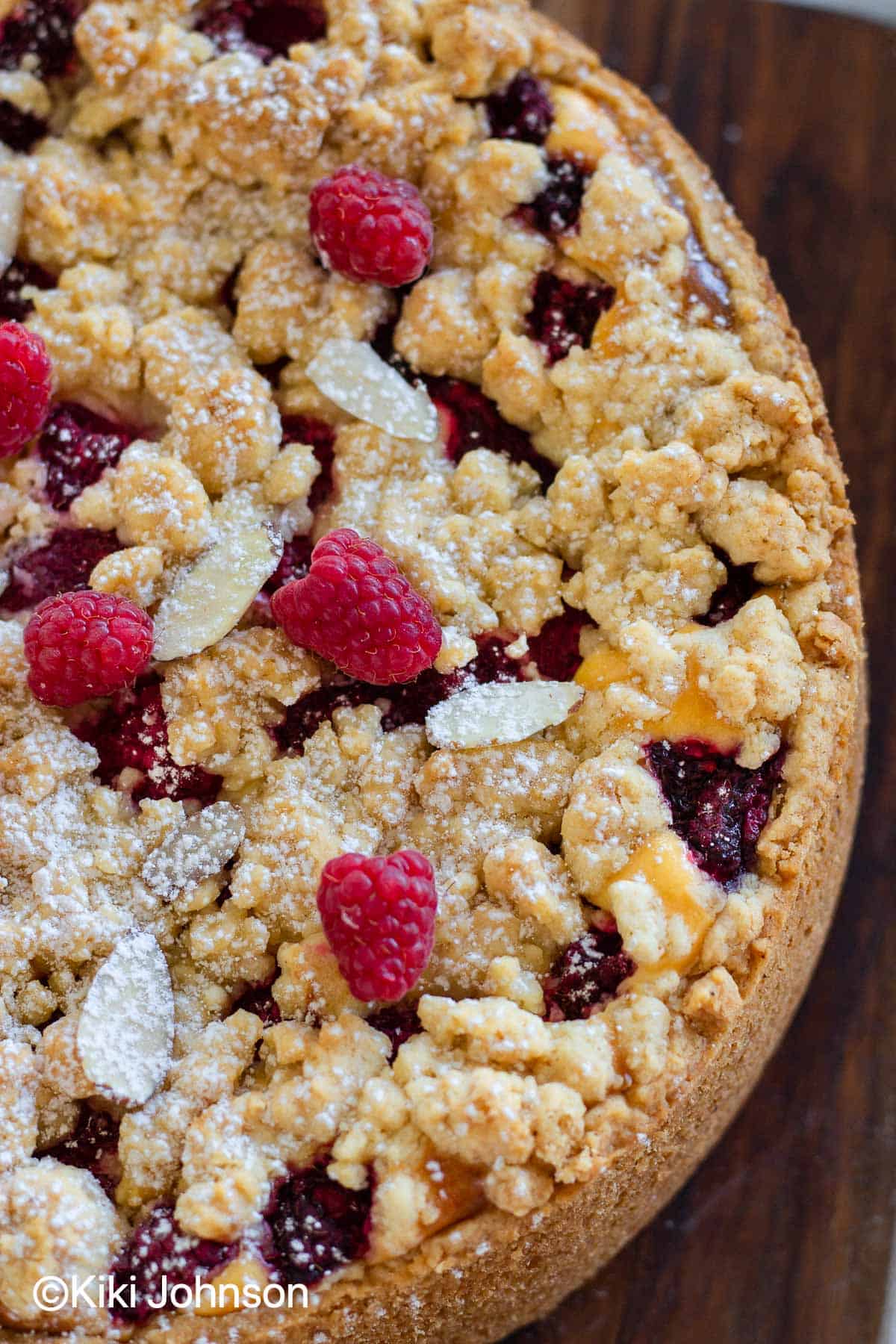 overhead shot of a baked German Raspberry Cheesecake with Streusel topping and fresh raspberries