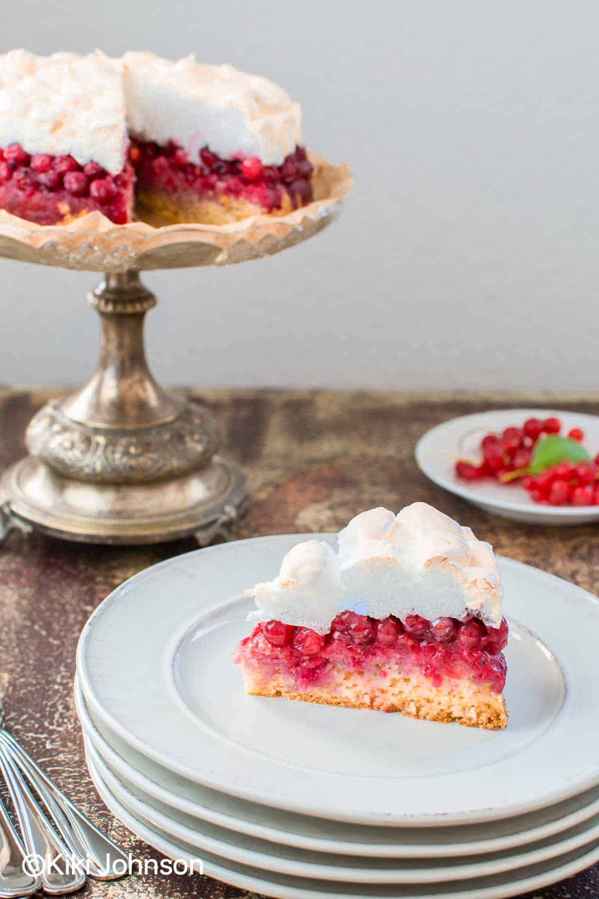 ein Stück Landfrauen Johannisbeer Kuchen mit Baiser und Rührteig auf einem Kuchenteller 