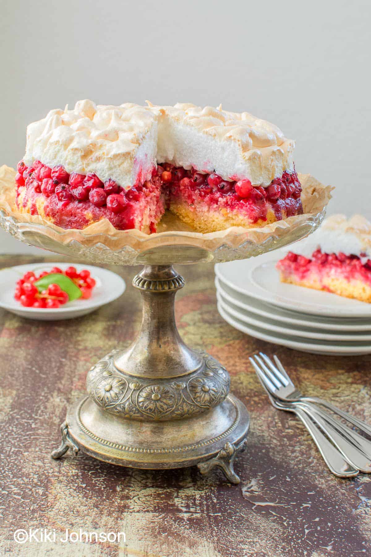 angeschnittener Johannisbeerkuchen mit Baiser auf einem Kuchenständer