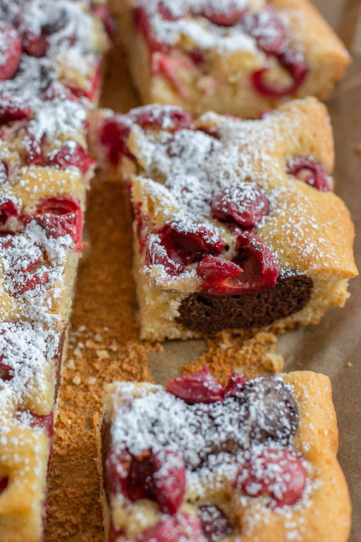 Marmorkuchen vom Blech mit Schattenmorellen auf einem Stück Backpapier 