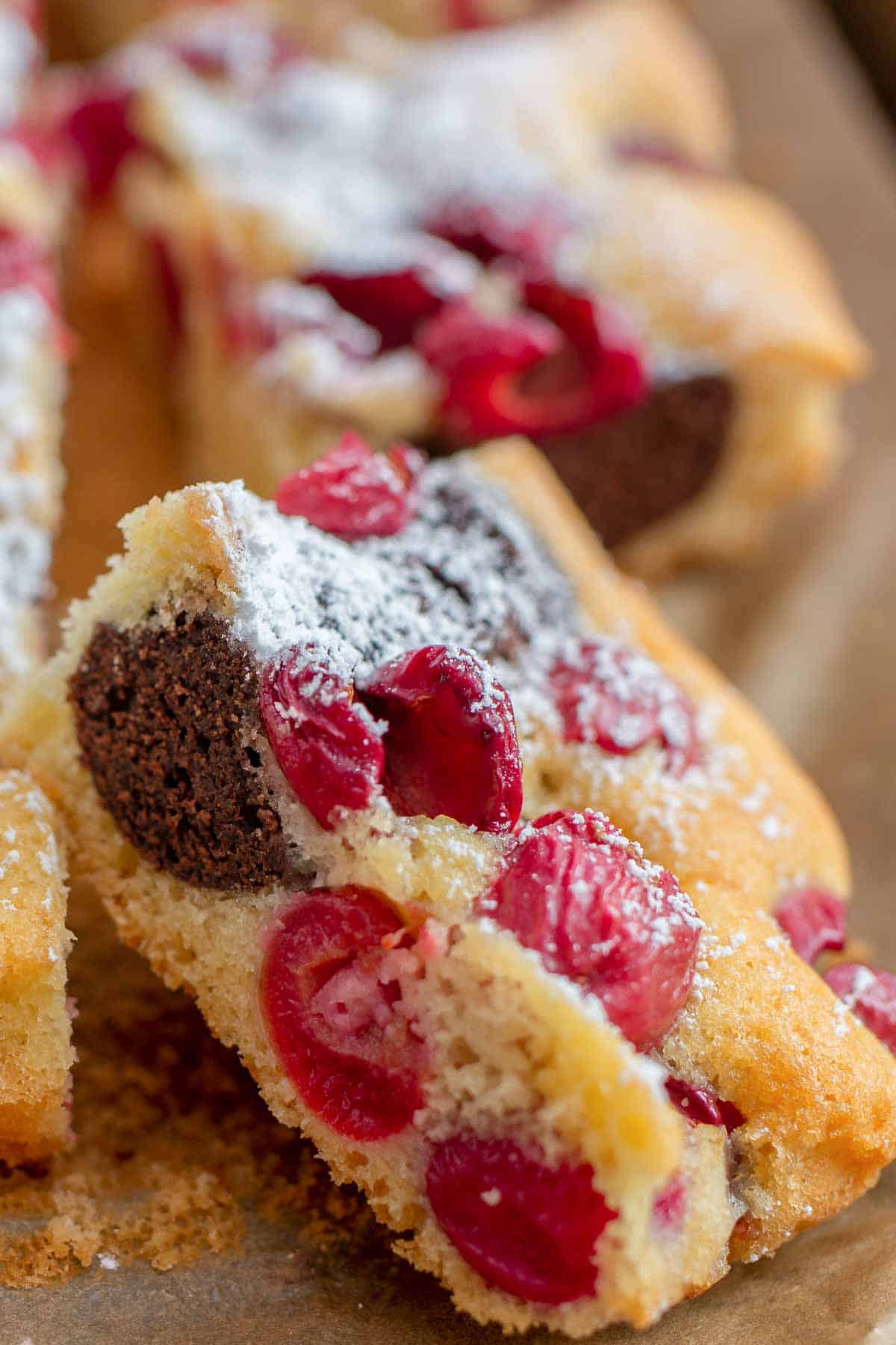 ein Stück Marmorkuchen vom Blech mit Kirschen auf einem Stück Backpapier