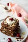 gluten free sheet pan pancakes stacked served with whipped cream and cherries