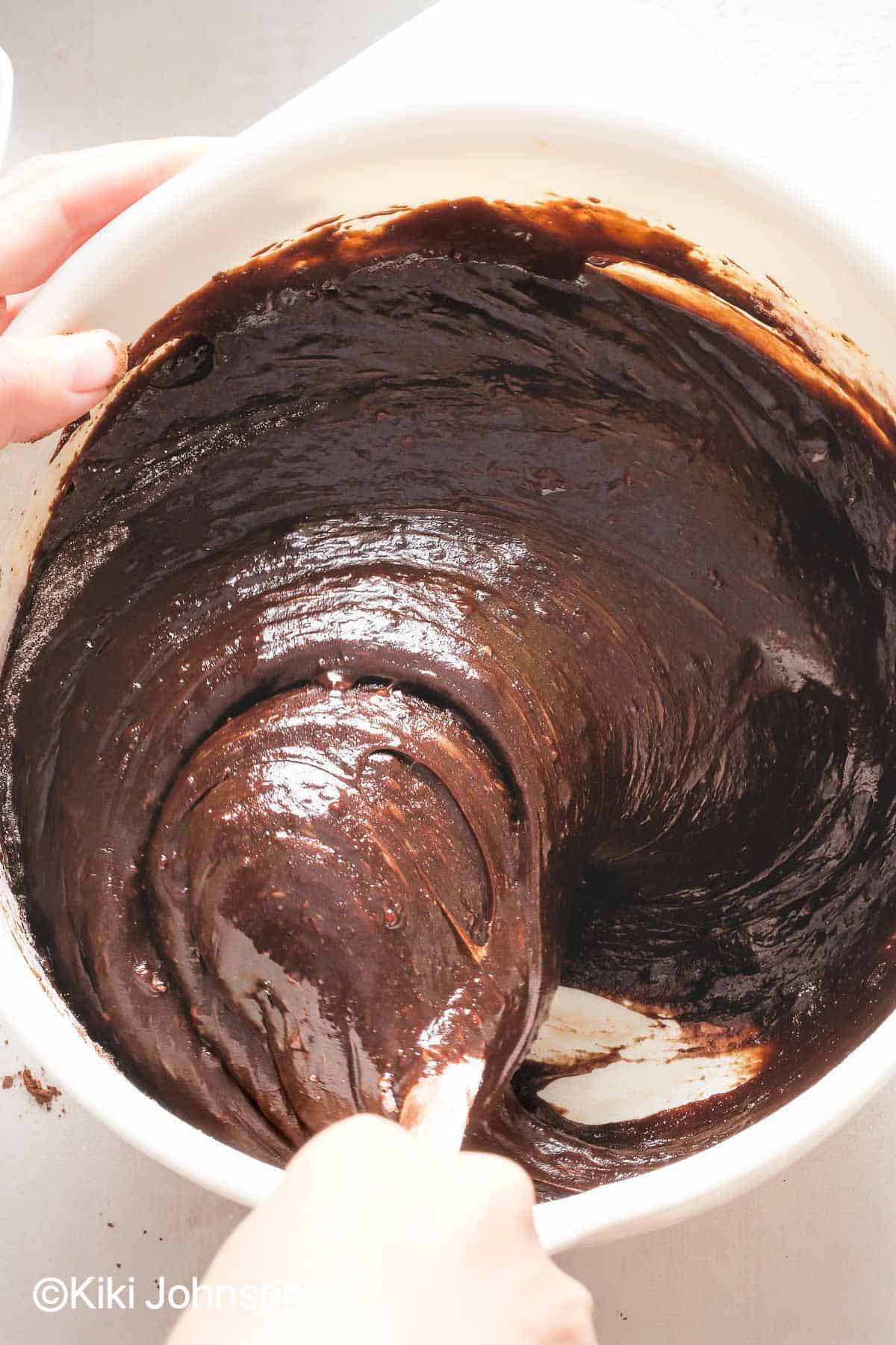 vegan chocolate cake batter being mixed in a bowl