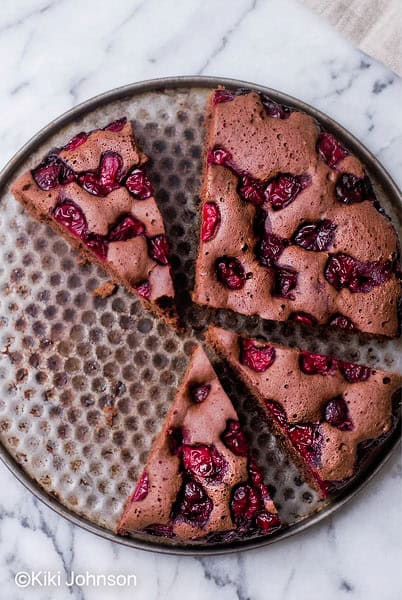 veganer schoko kirsch kuchen aif einem Marmortisch