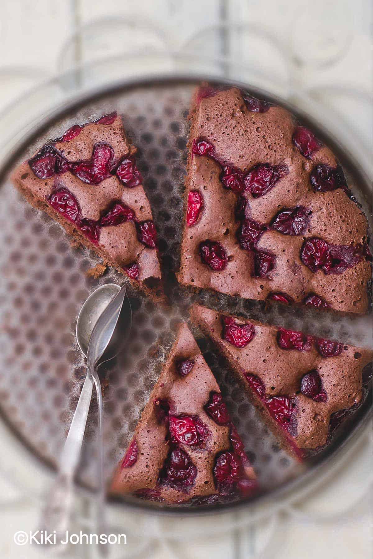 angeschnittener veganer Schoko Kirsch Kuchen auf dem Boden einer Springform