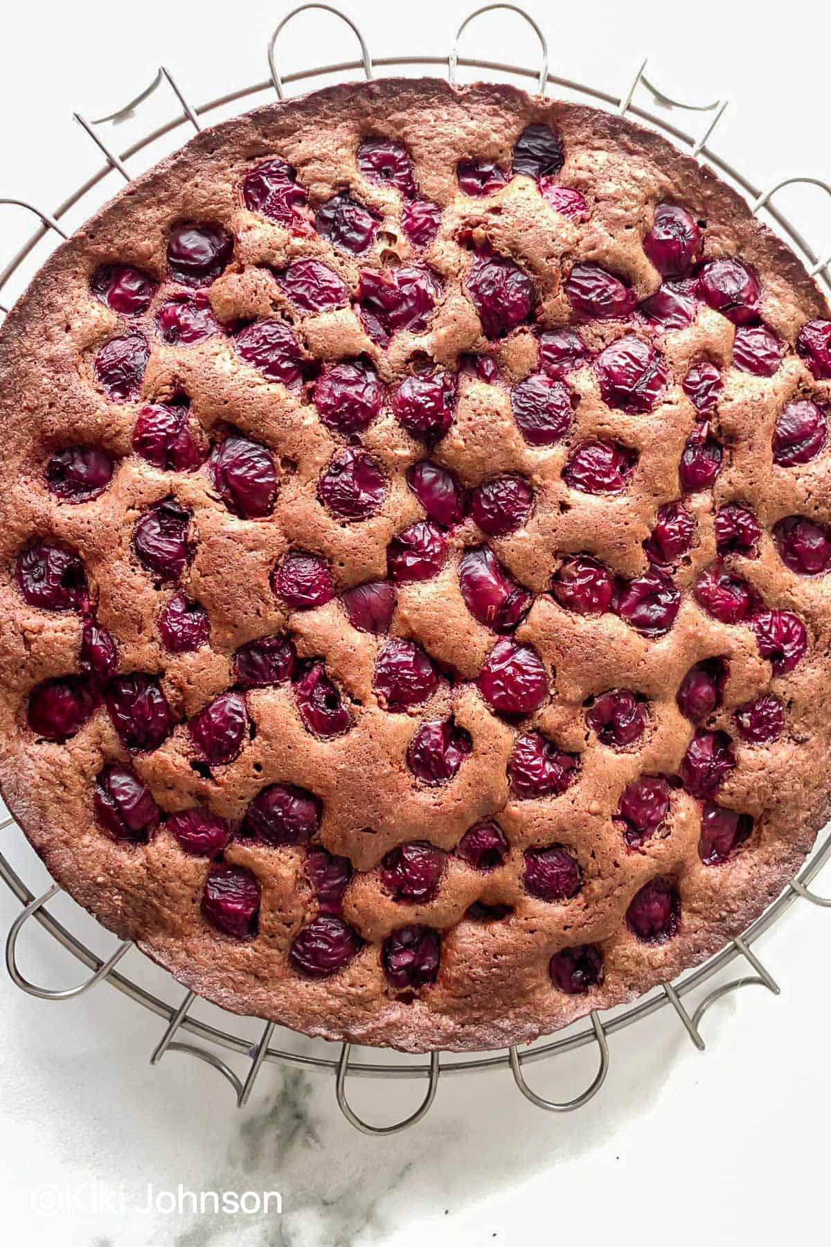 freshly baked vegan chocolate cherry cake on a cooling rack