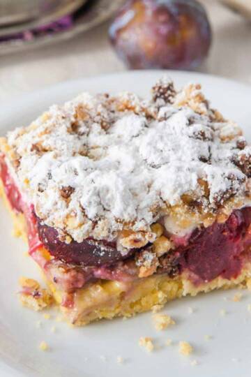 plum coffee cake with streusel topping on a cake plate