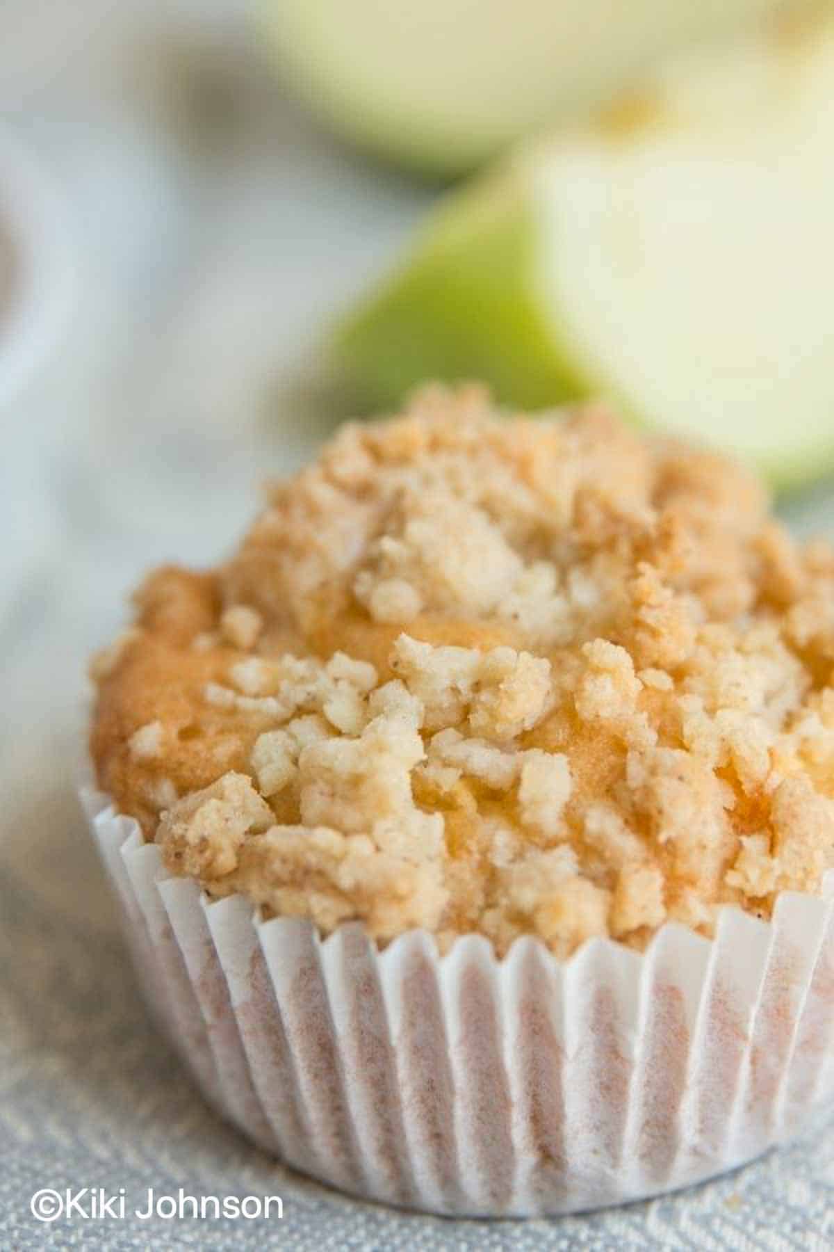 Saftiger Apfel Joghurt Muffin mit Streusel mit grünen äpfeln im Hintergrund